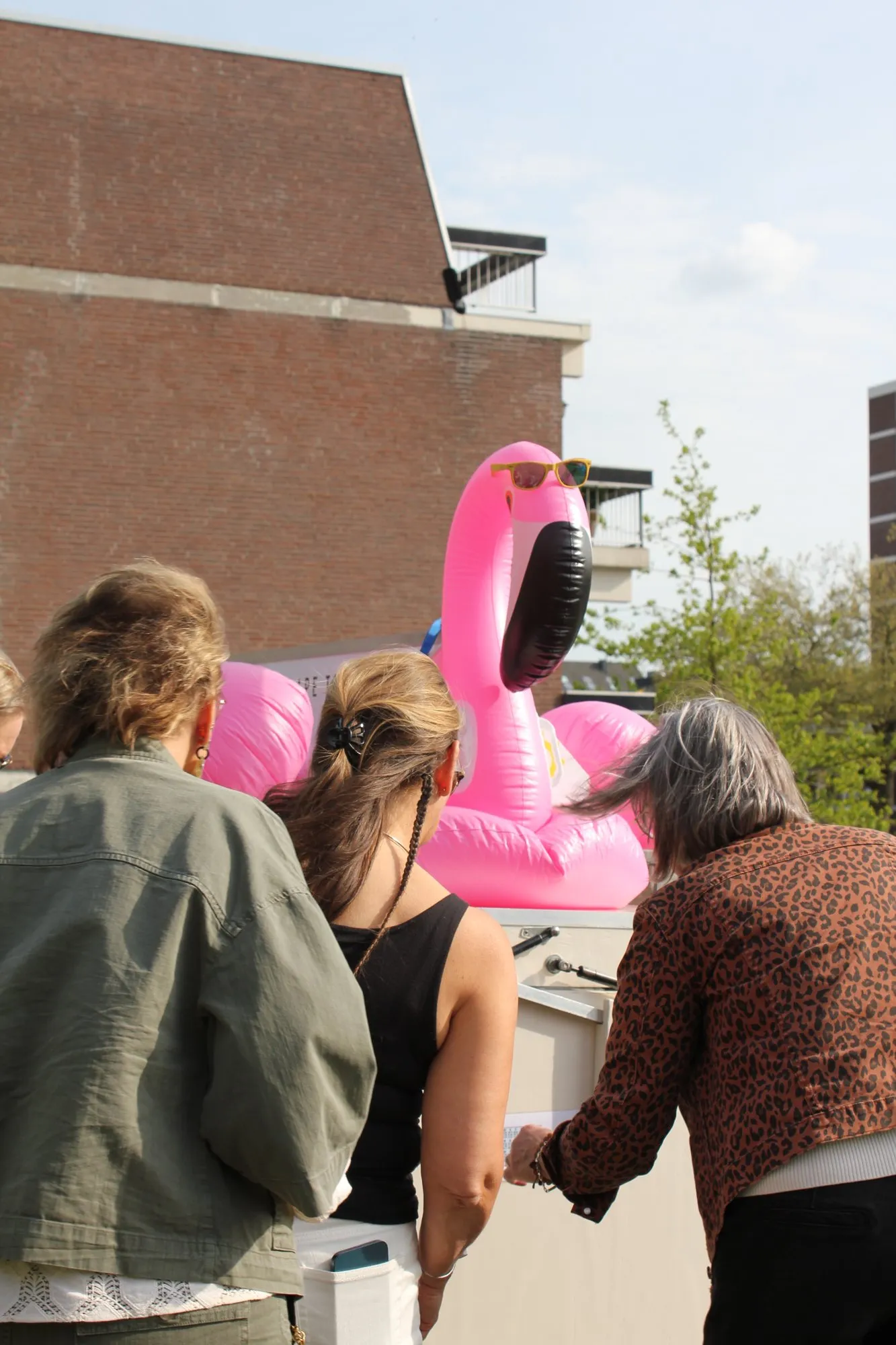Drie collega's buigen zich samen over de escape trailer tijdens een teambuilding op kantoor