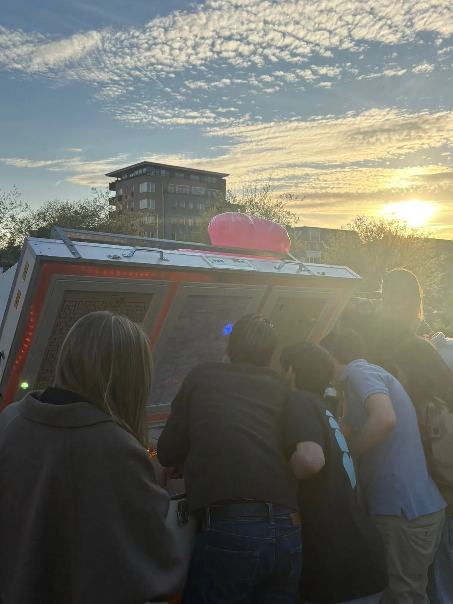 Spelers bij de verlichte escape trailer tijdens een schoolfeest bij zonsondergang