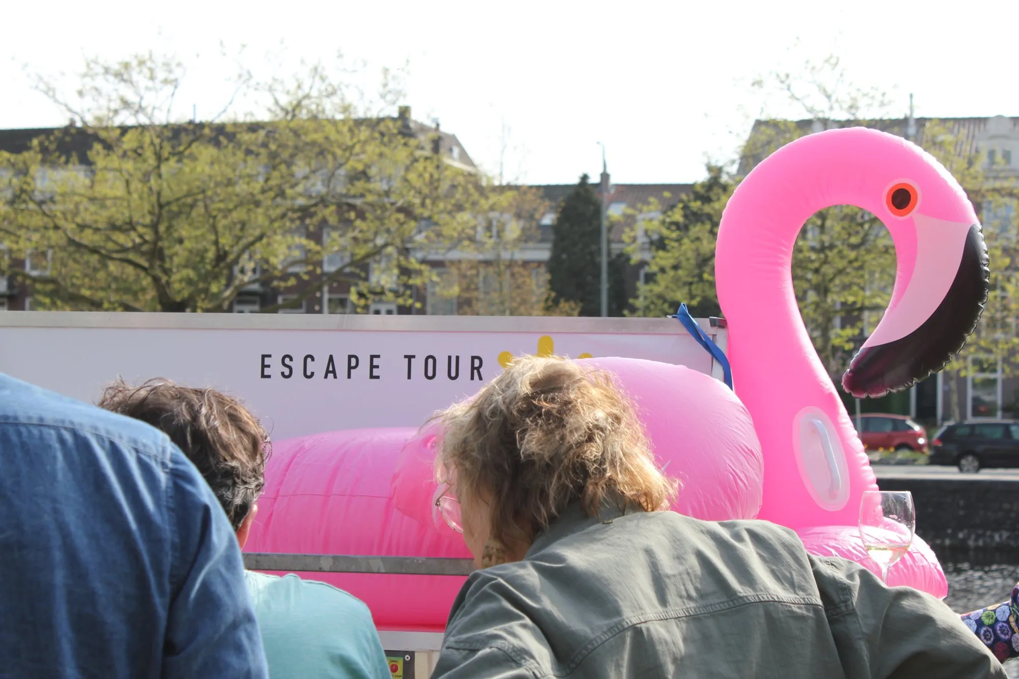 Bezoekers bij de escape trailer met het Escape Tour-bord en de roze flamingo op een open dag