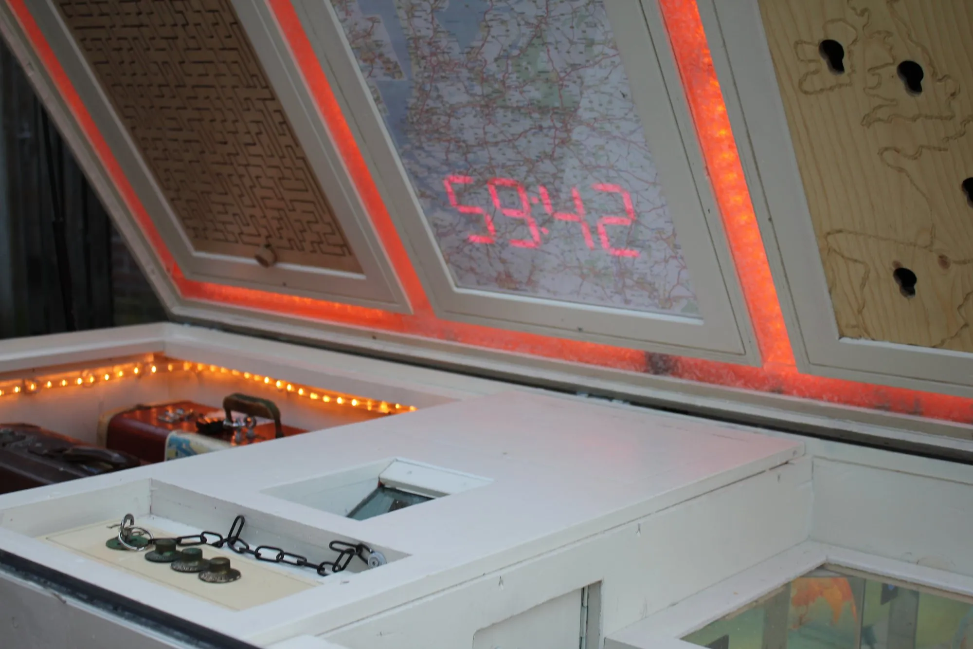 Binnenkant van de escape trailer: landkaart, doolhof en aftelklok met oranje verlichting